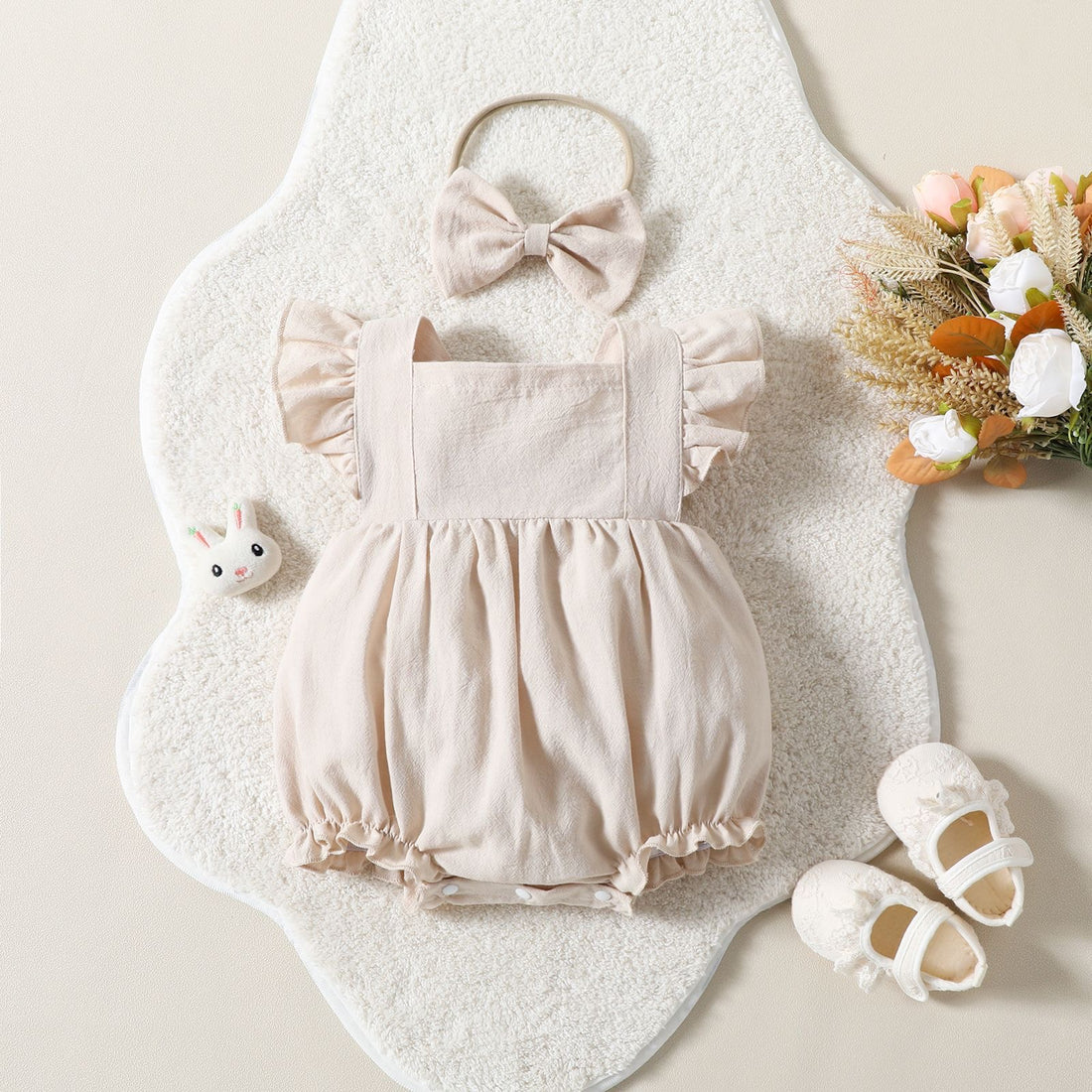 Cute baby playsuit in beige.